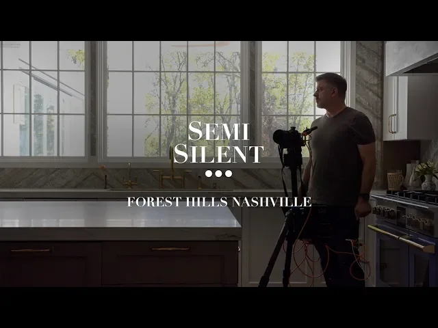 A man standing in a kitchen with large windows, holding a tripod-mounted camera, with the text "Semi Silent" and "Forest Hills Nashville" overlaid on the image.