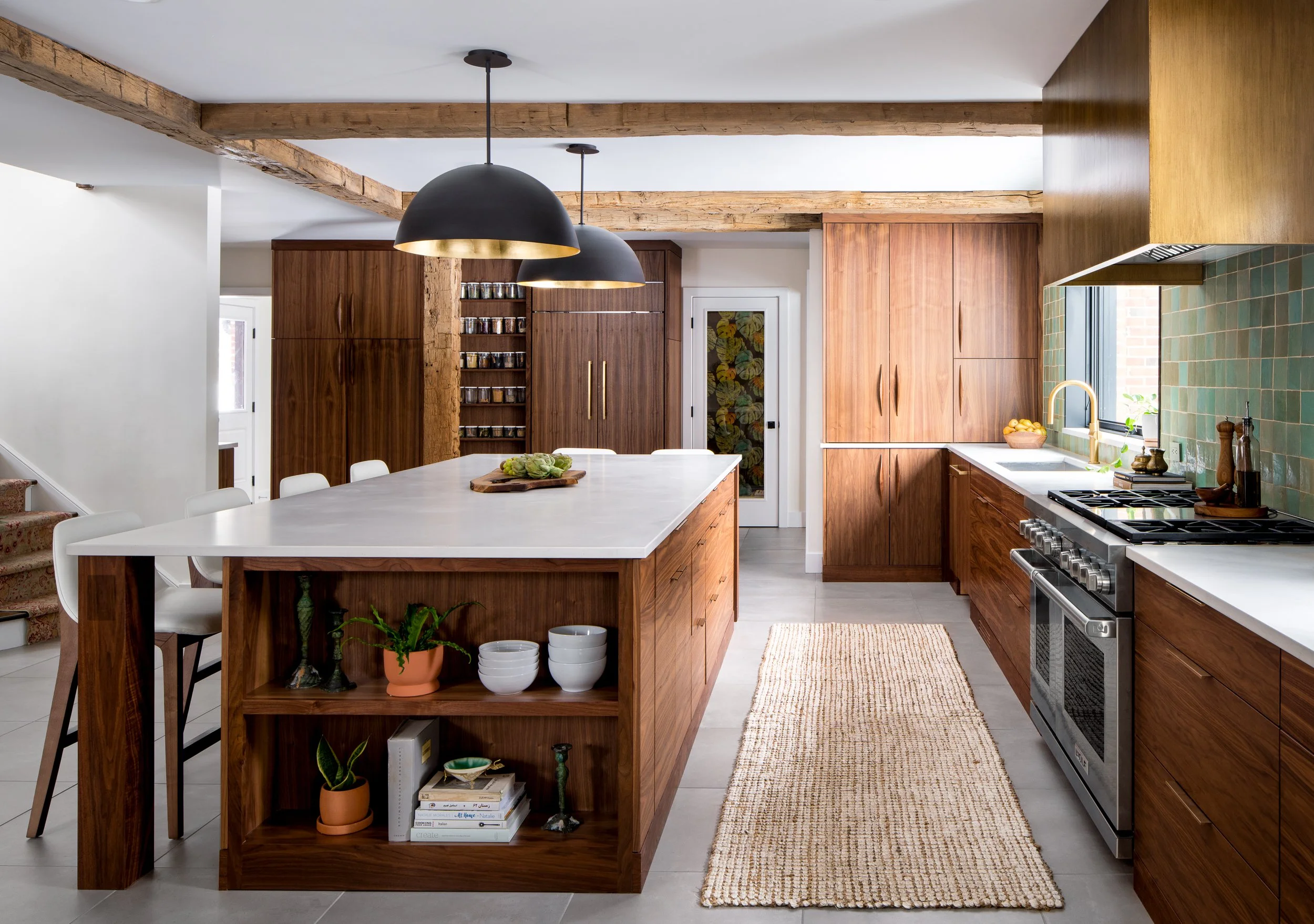 A bathroom with a green-tiled shower and walnut cabinetry.
