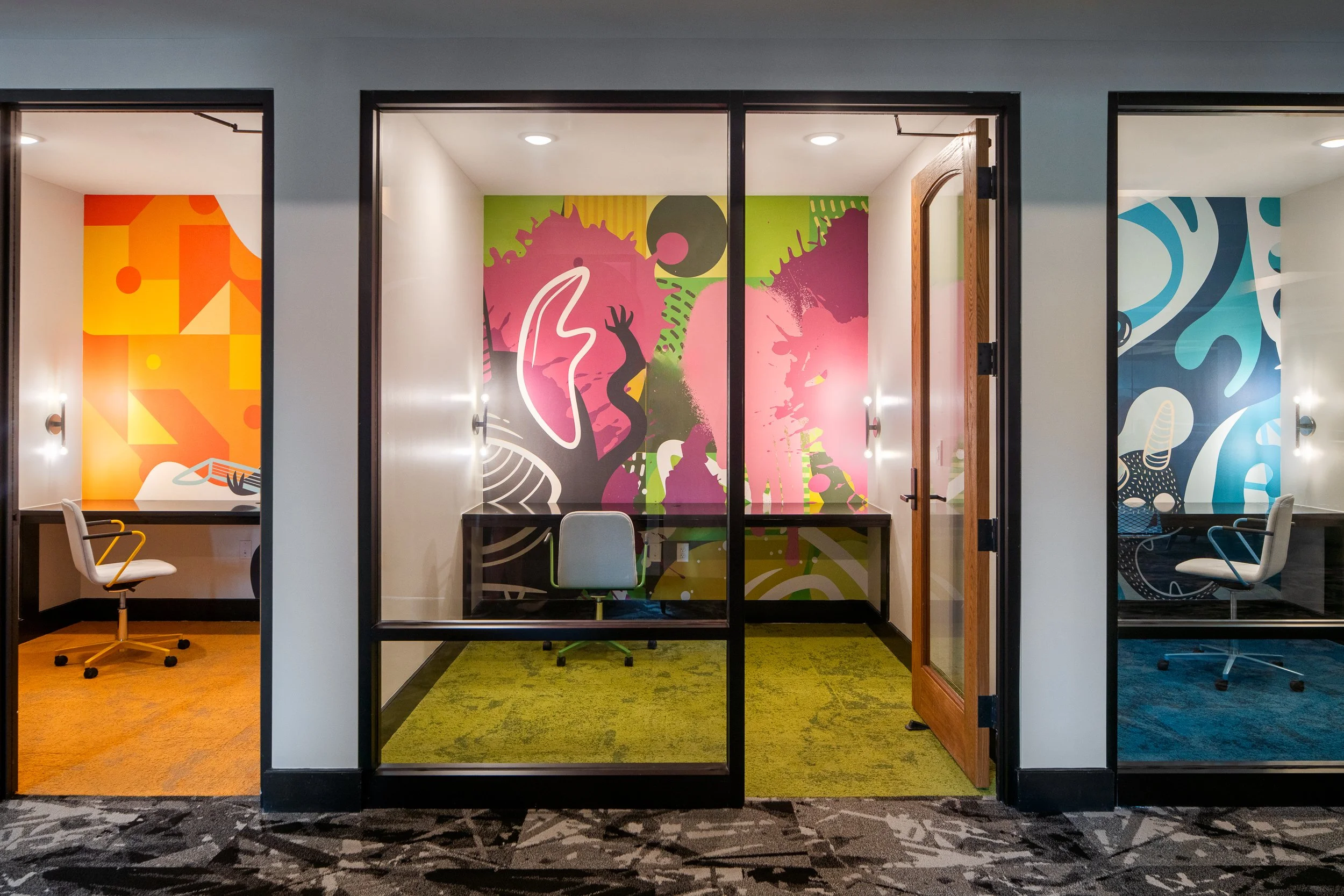 Private workspaces with vibrant murals and modern furniture.