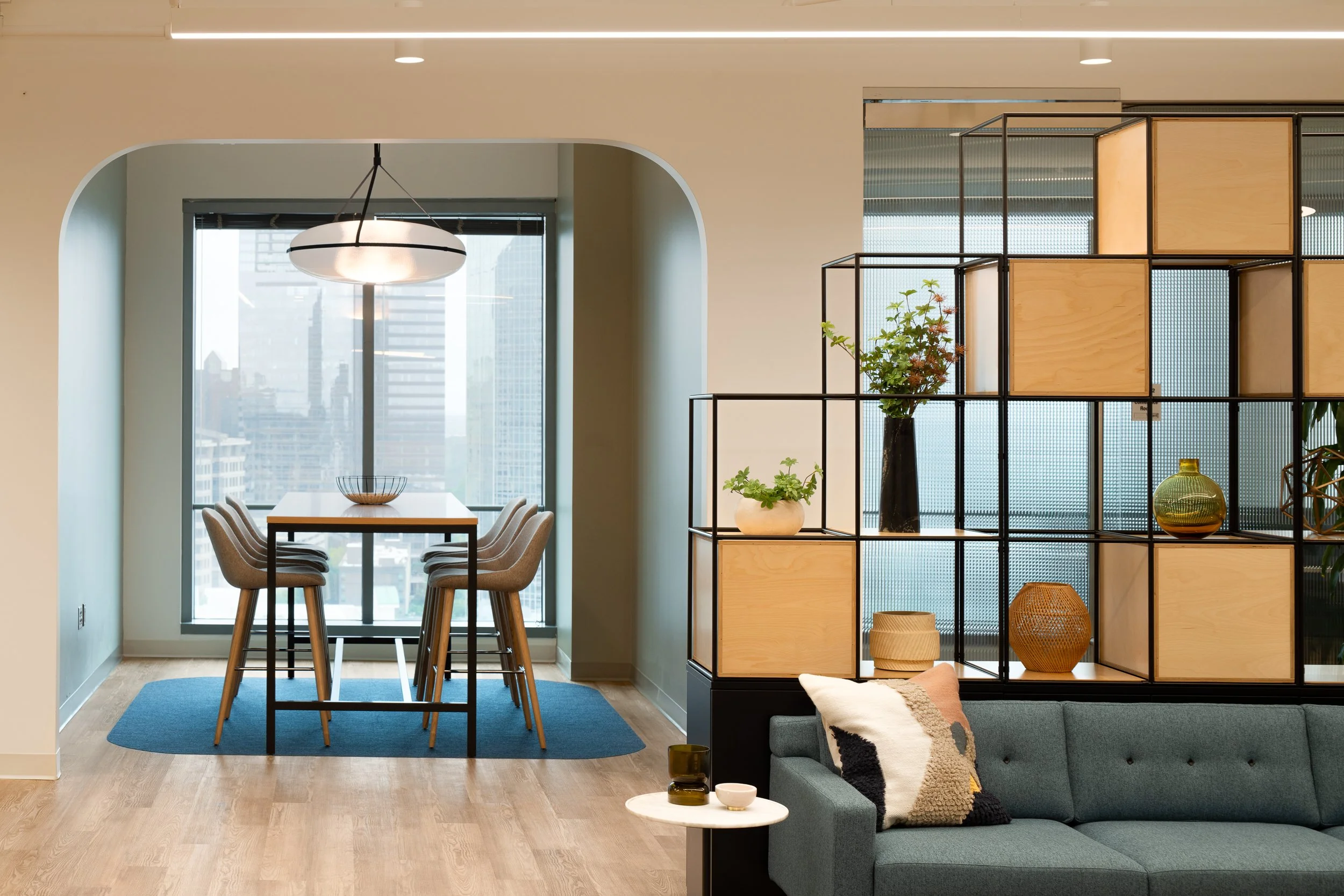 Open office seating with decorative shelving and city skyline.