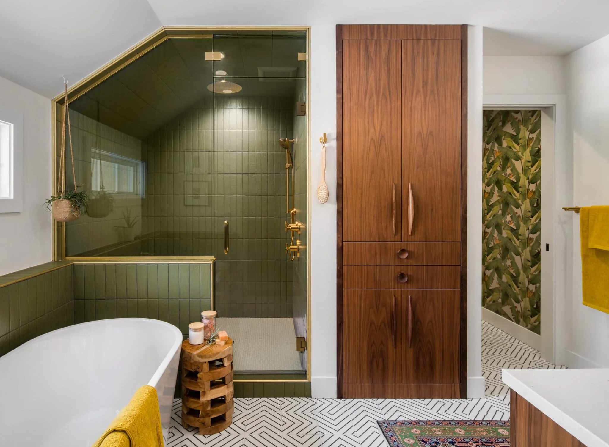 Bathroom with green tile shower, freestanding tub, wood cabinetry, and patterned floor tile.