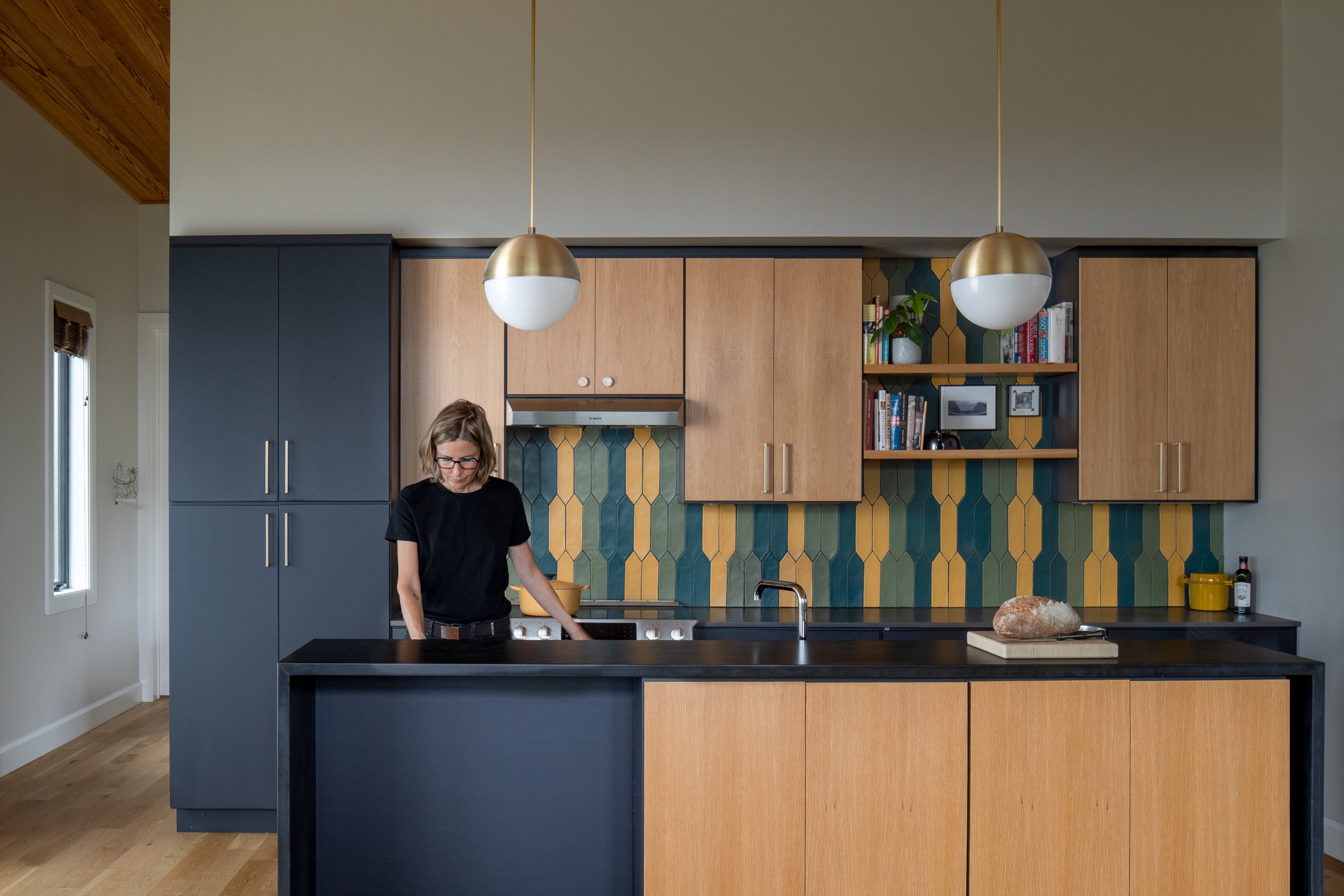 Contemporary kitchen with dark cabinetry and colorful tile backsplash.