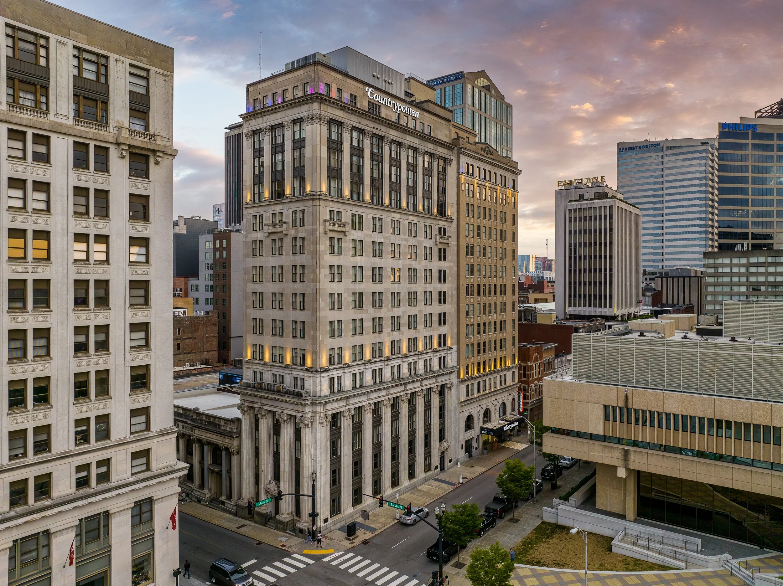 The exterior at dusk, the Nashville skyline framing the building from across the street.