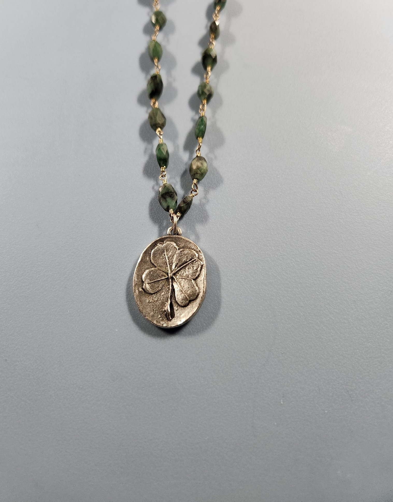 T6900 - SILVER CLOVER NECKLACE WITH RAW EMERALD GLASS.png
