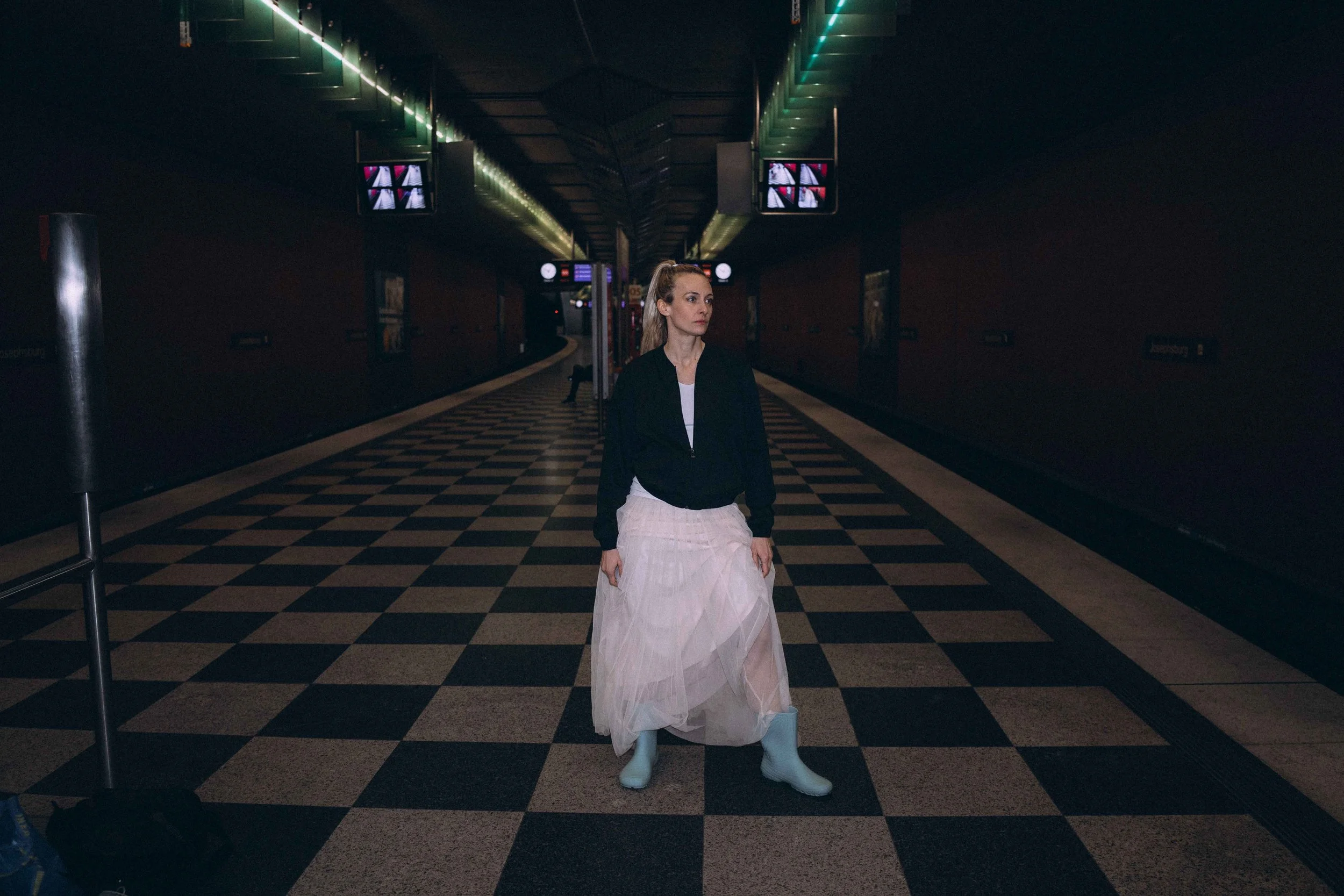 Lifestylefotos in München. Frau mit Gummistiefel und Tüllrock in einer U-Bahn Station in München.