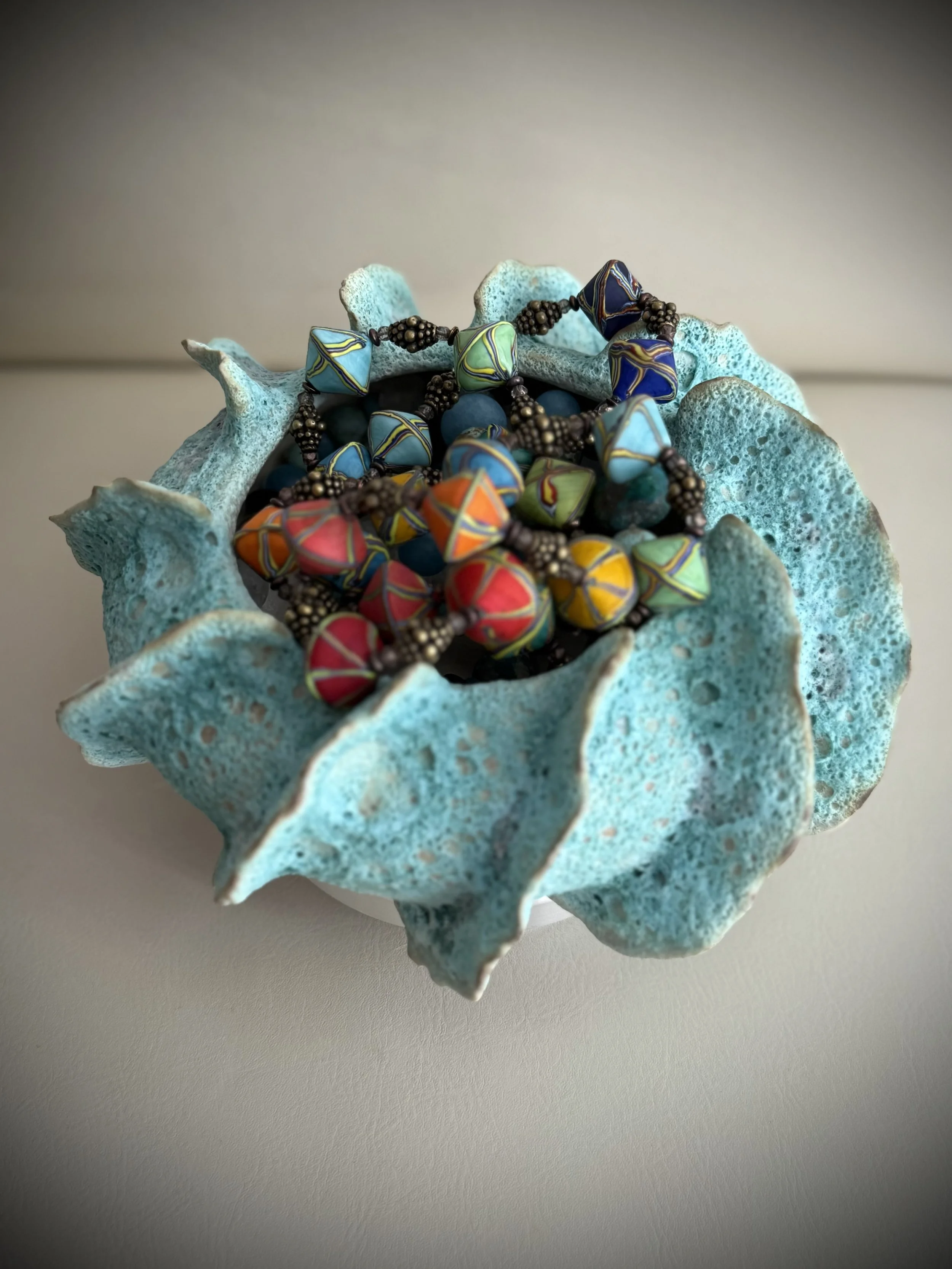 ceramic stoneware handmade sea blue textured vase with styling suggestion to hold glass necklace. statement piece. unique gift
