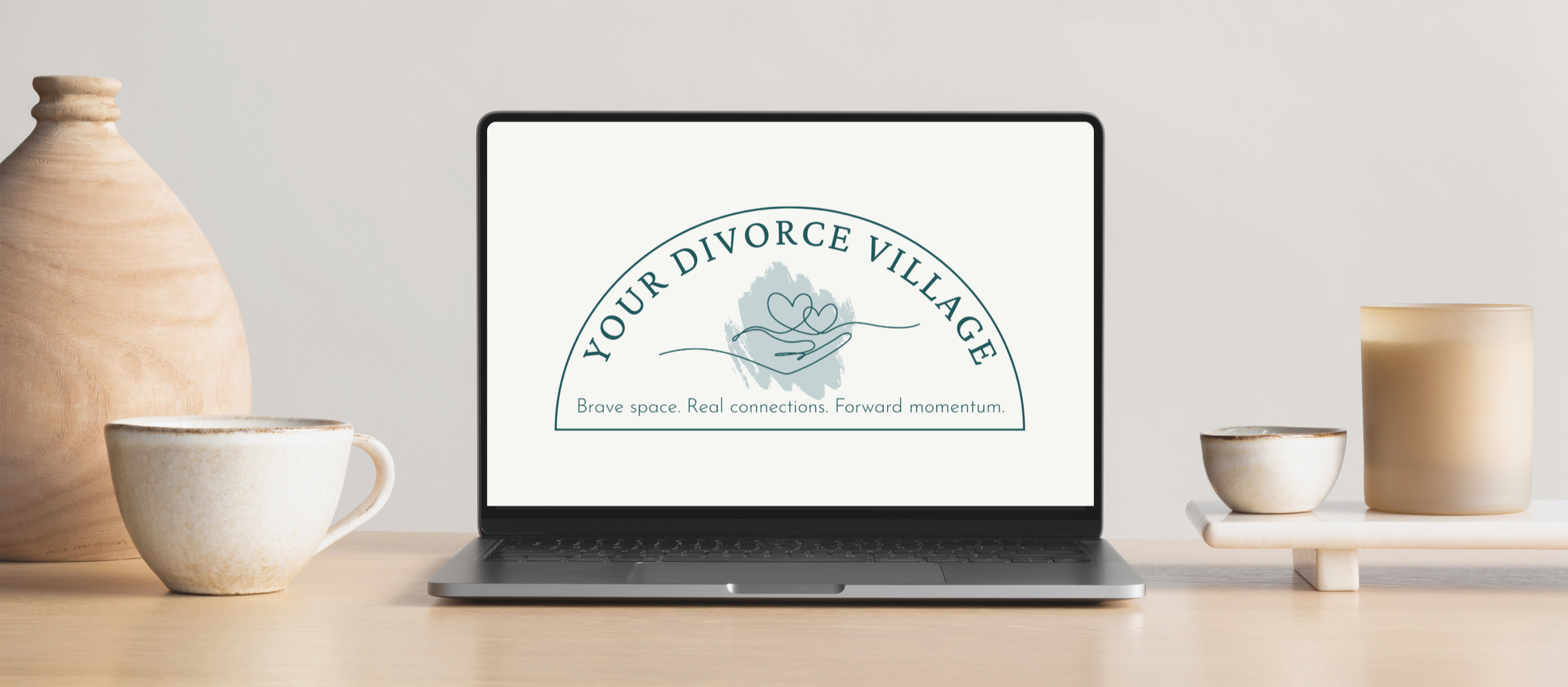 Laptop on a desk displaying the Your Divorce Village logo, representing the virtual divorce support group program