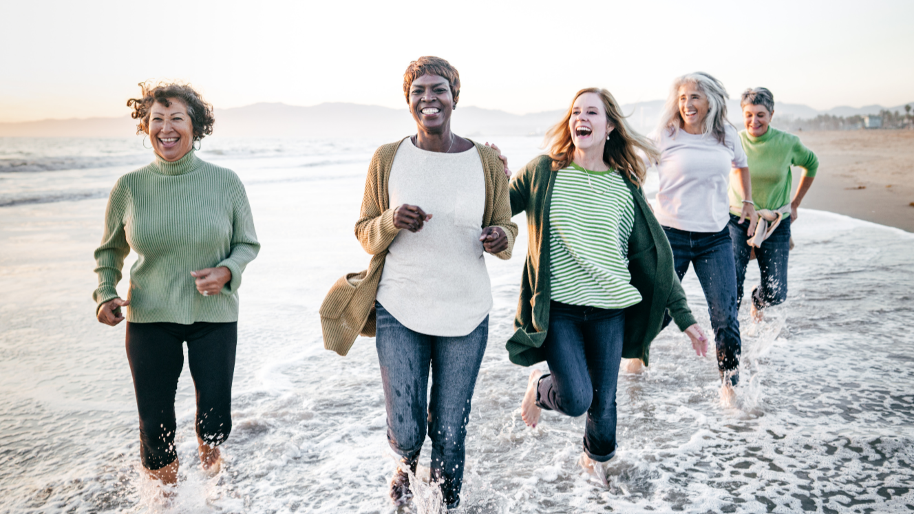 Women running on the beach, embracing freedom and joy after divorce. Their journey symbolizes emotional resilience, and the empowerment that comes from reclaiming confidence after divorce and finding community through divorce coaching.