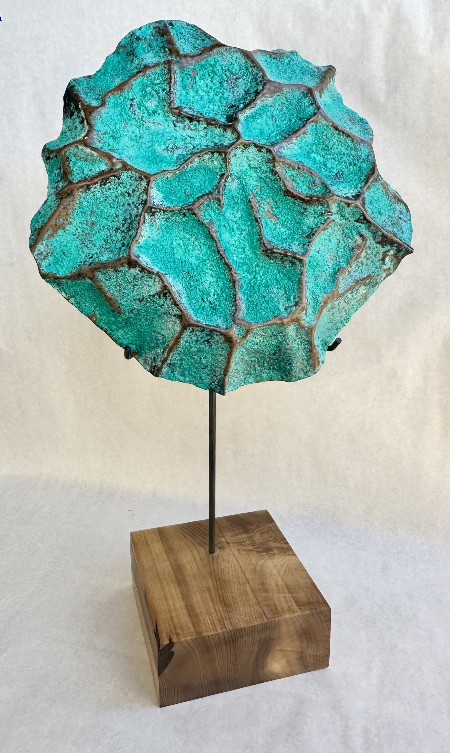 Copper sheet, hammer, blowtorch, reagents, hand-crafted steel armature, myrtle wood base, 21" x 11.5" x 7"