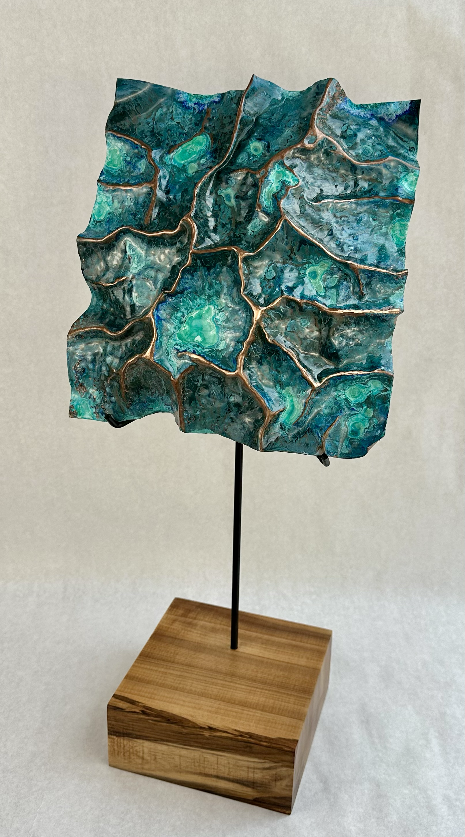 Copper sheet, hammer, blowtorch, reagents, hand-crafted steel armature, myrtle wood base, 21" x 9.5" x 7"