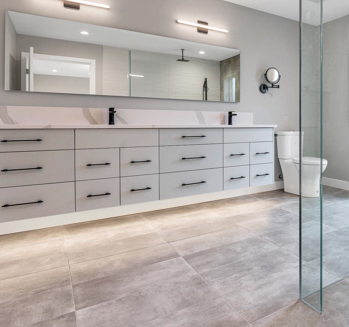 Modern bathroom with large mirror, floating vanity, and glass shower