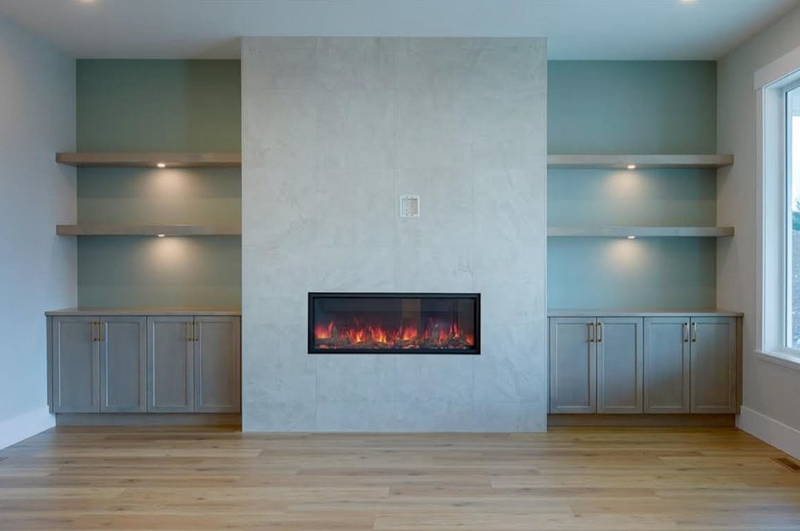 Modern built-in fireplace with light wood cabinets and shelves, recessed lighting, green accent wall, and hardwood floors.