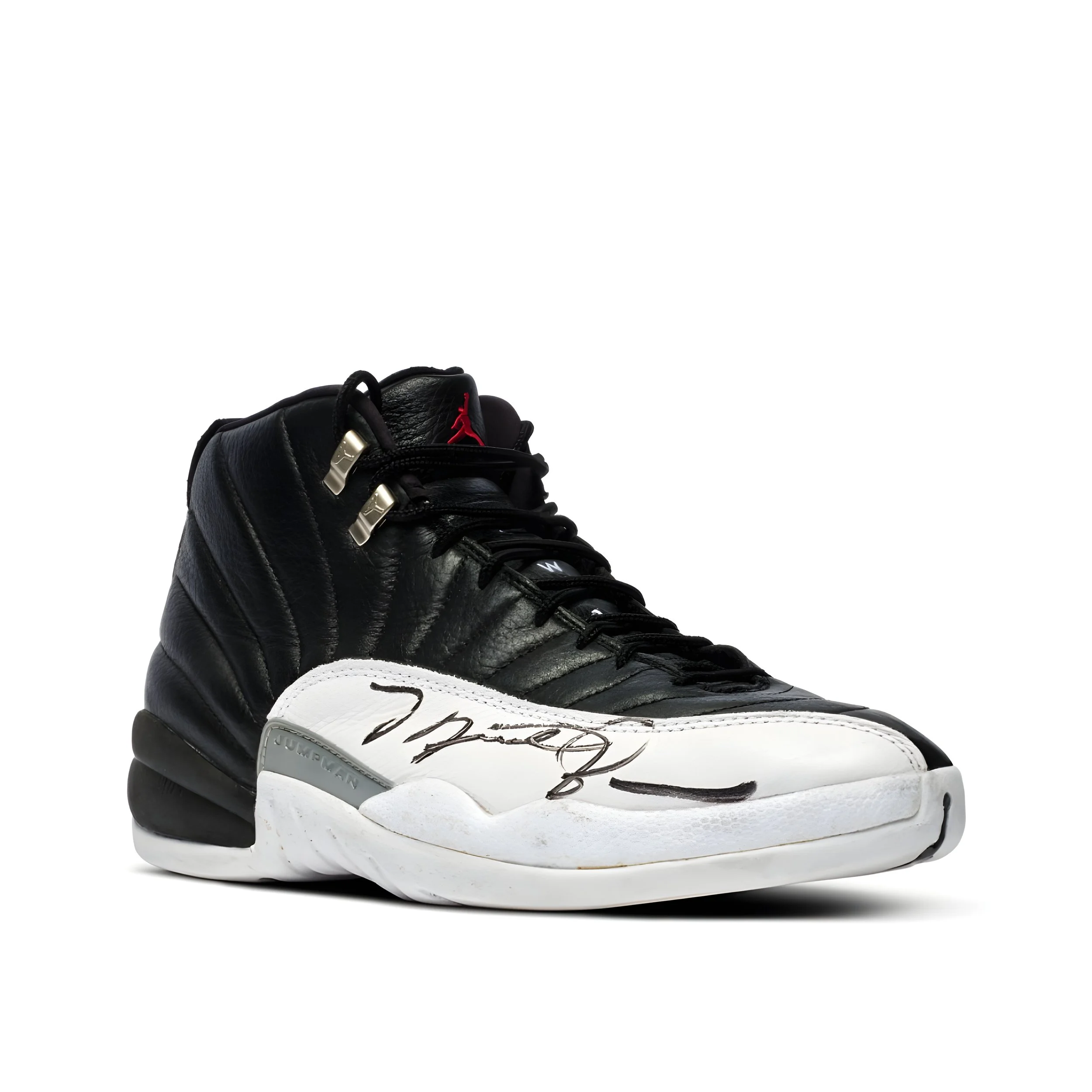 Black and white Air Jordan sneaker with a red Jumpman logo on the tongue and a signature on the toe cap.