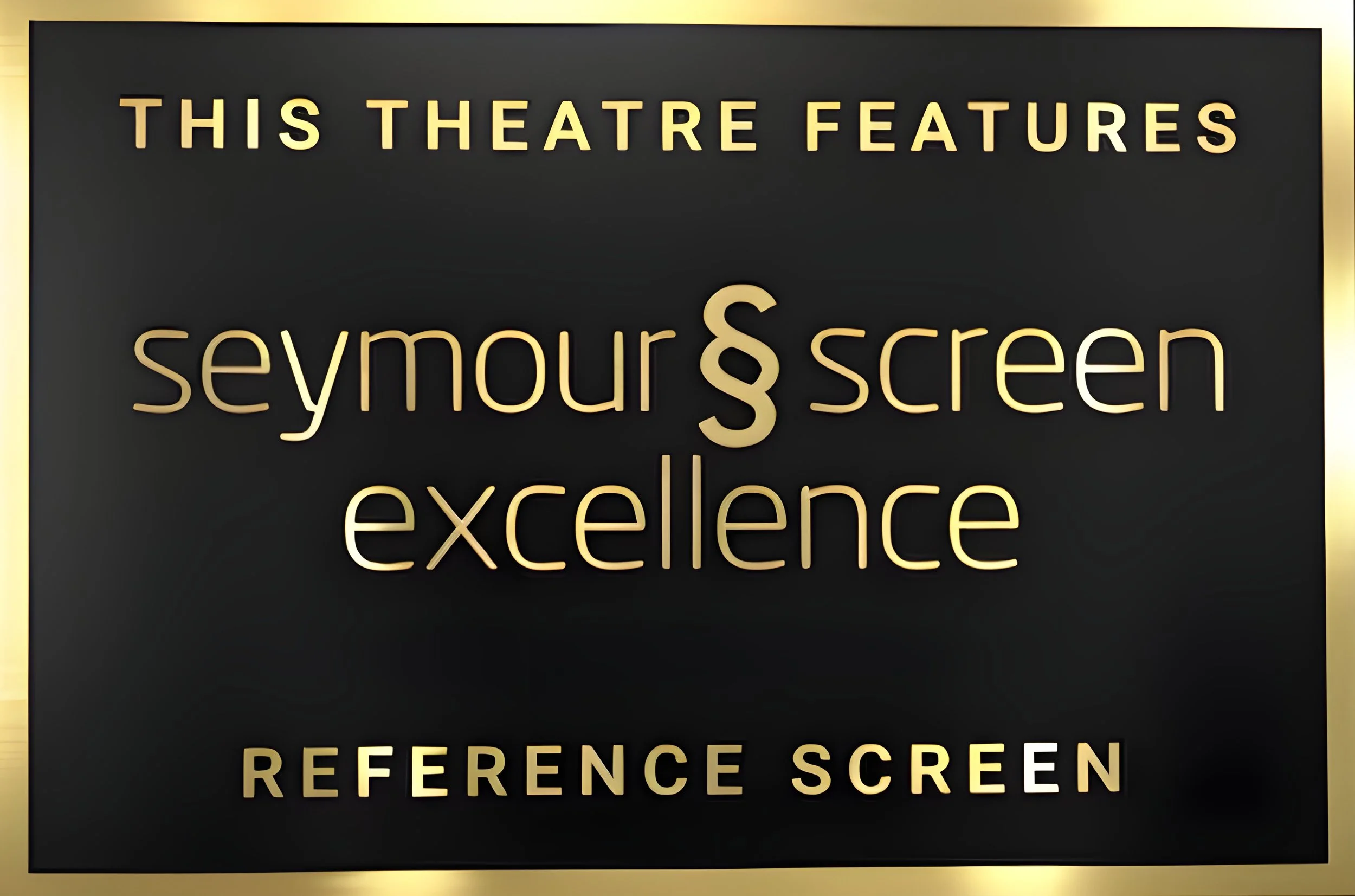 Sign advertising features of a Seymour & Screen theatre, with the word 'excellence' and 'reference screen' on a black background with gold lettering.