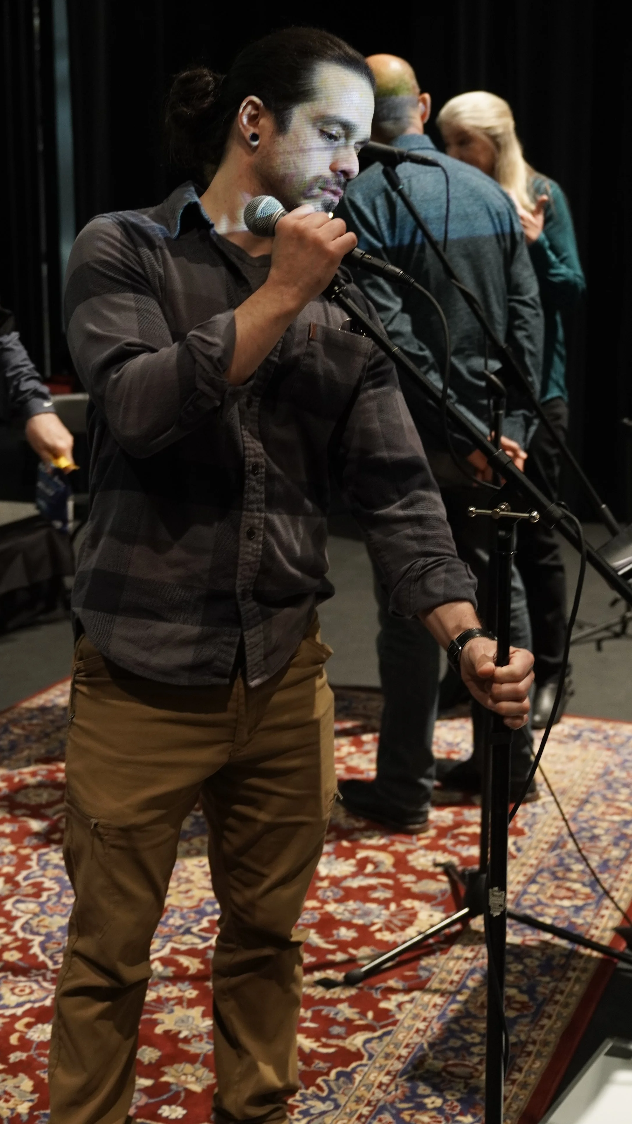 Christian Rodriguez-Ortiz of Christian Sound meticulously arranging a vocal microphone for a live performance.