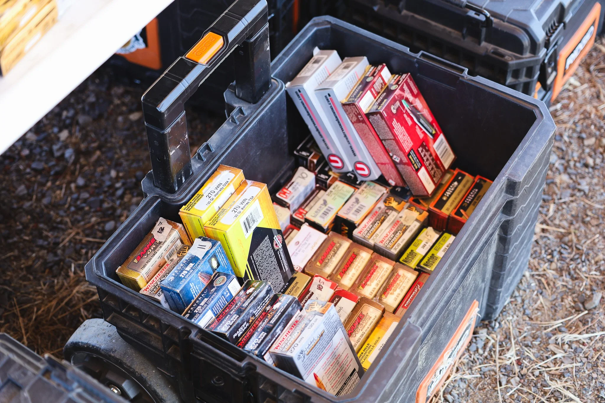 Open black toolbox containing boxes of ammunition at a local range