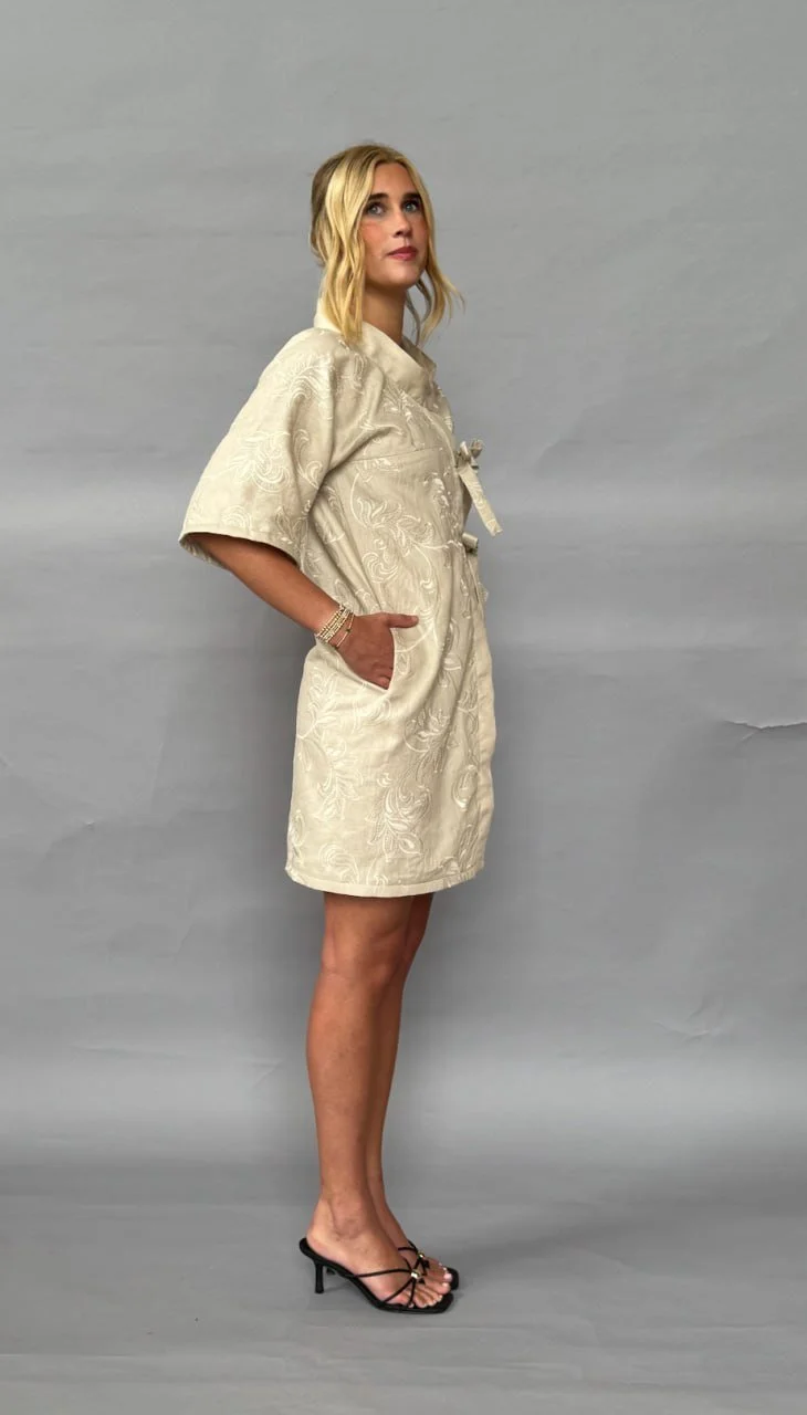 Model wearing Gracie Monsees's ivory zero-waste kimono-style dress in a side three-quarter studio view.