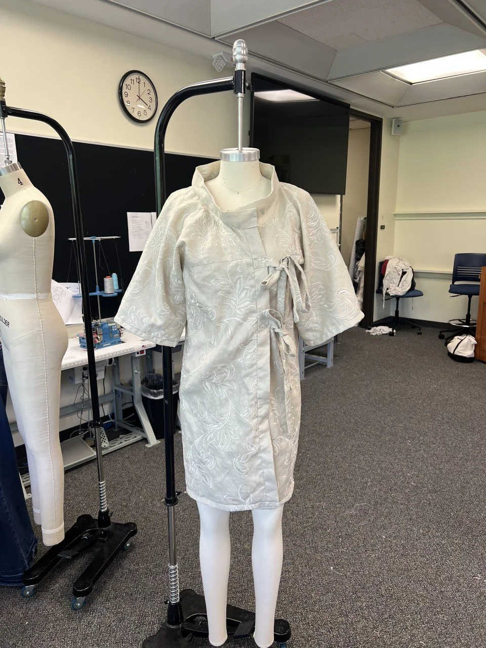 Finished ivory zero-waste garment displayed on a full-size dress form.