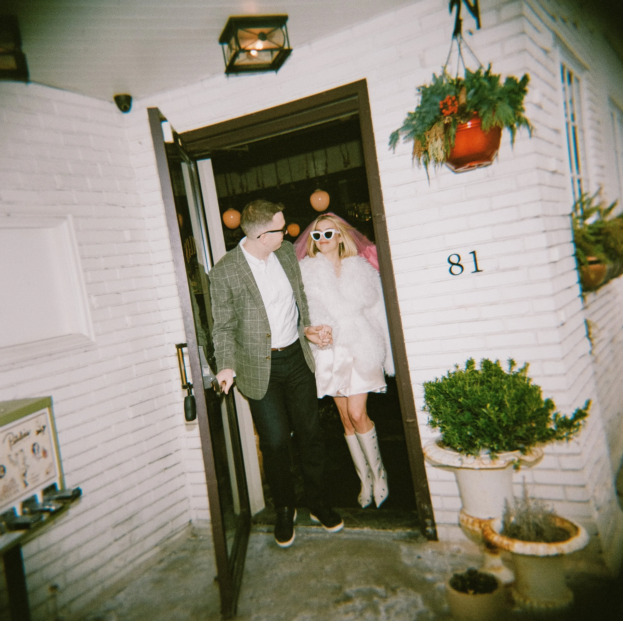 couple exits the restaurant wearing sunglasses for their engagement photoshoot