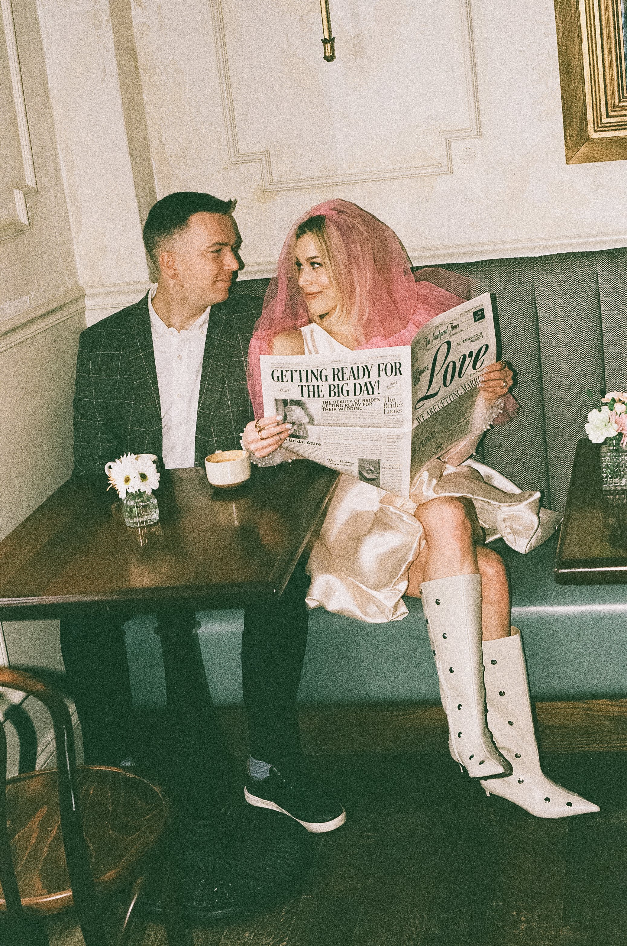 couple reads the newspaper together announcing their engagement