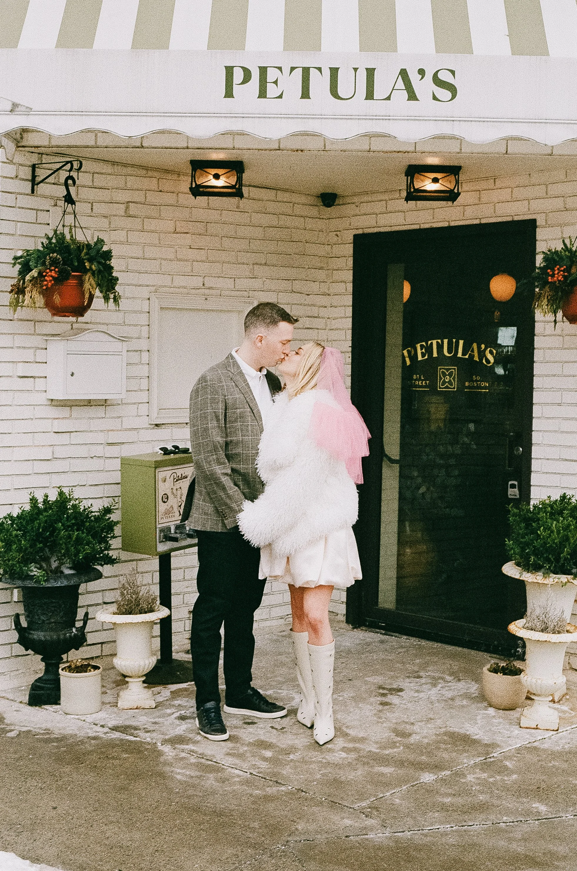 engaged couple kissing in front of petula's in south boston in vintage clothing