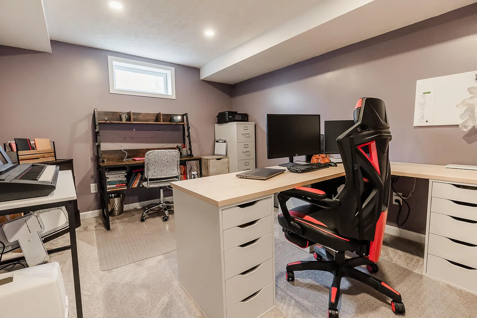 Home office with desk, computer monitors, gaming chair, and shelves