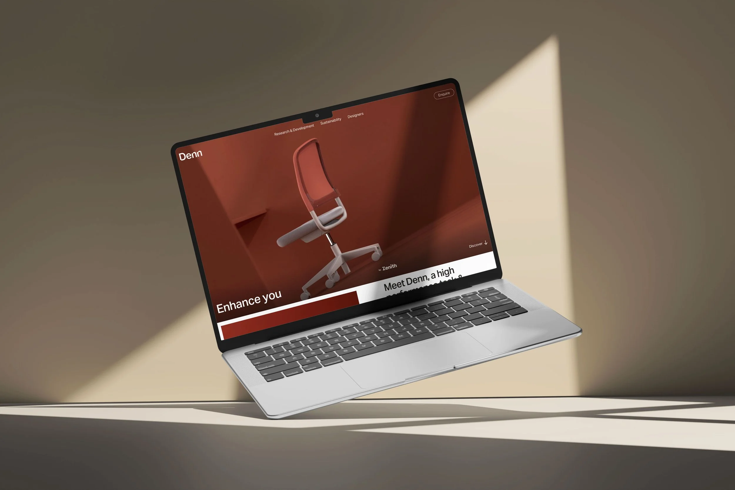 Laptop displaying a website with a modern office chair on screen, set against a warmly lit background.