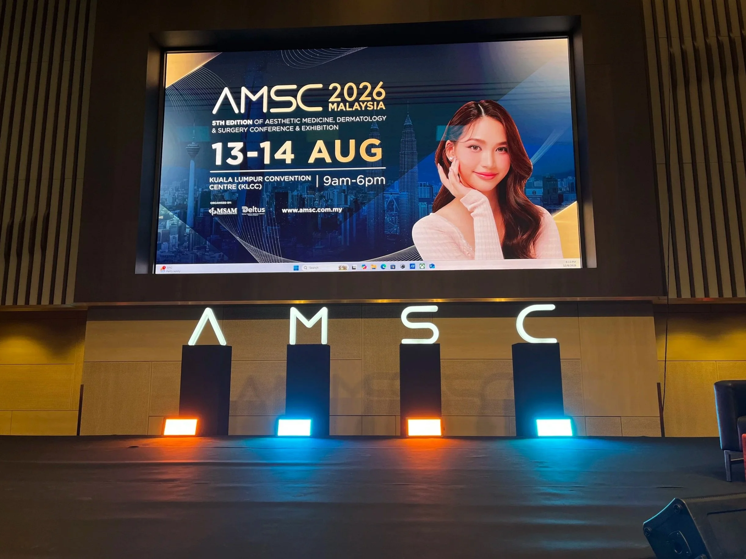 Digital display at the Kuala Lumpur Convention Centre advertising the 2026 Aesthetic Medicine, Dermatology, and Surgery Conference & Exhibition in Malaysia, August 13-14, 2026, showing a woman with long dark hair.