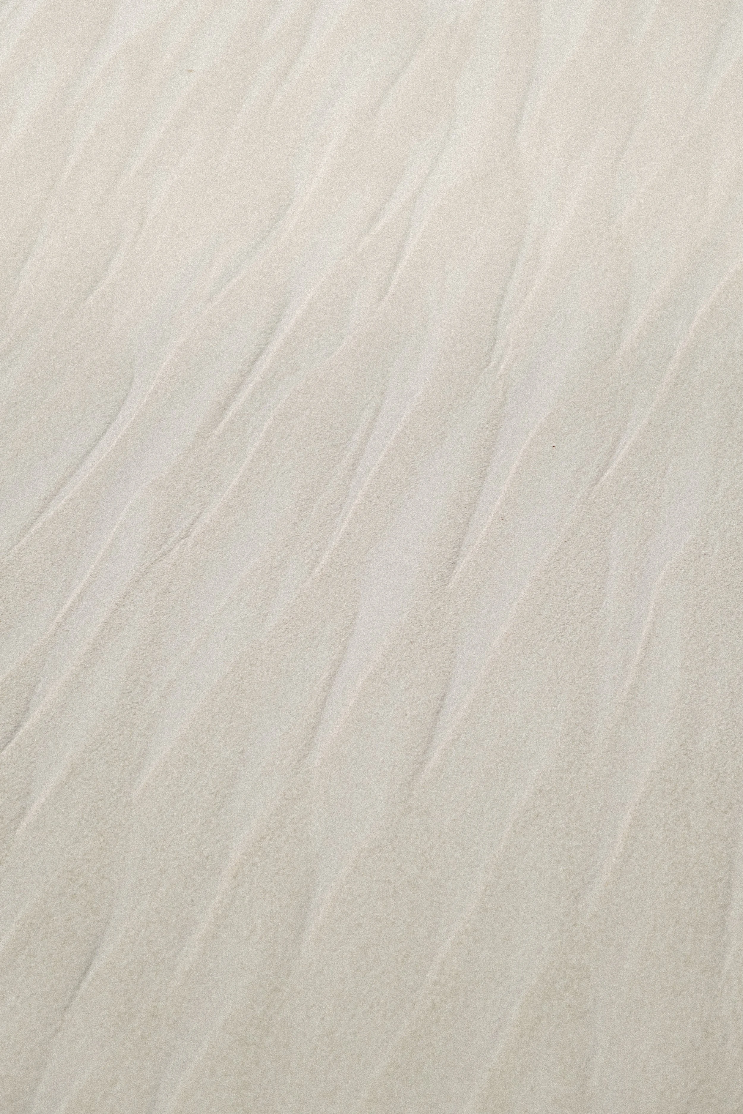 Close-up view of sand texture with natural patterns and ripples.