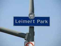 Street sign reading 'Leimert Park' against a clear blue sky.