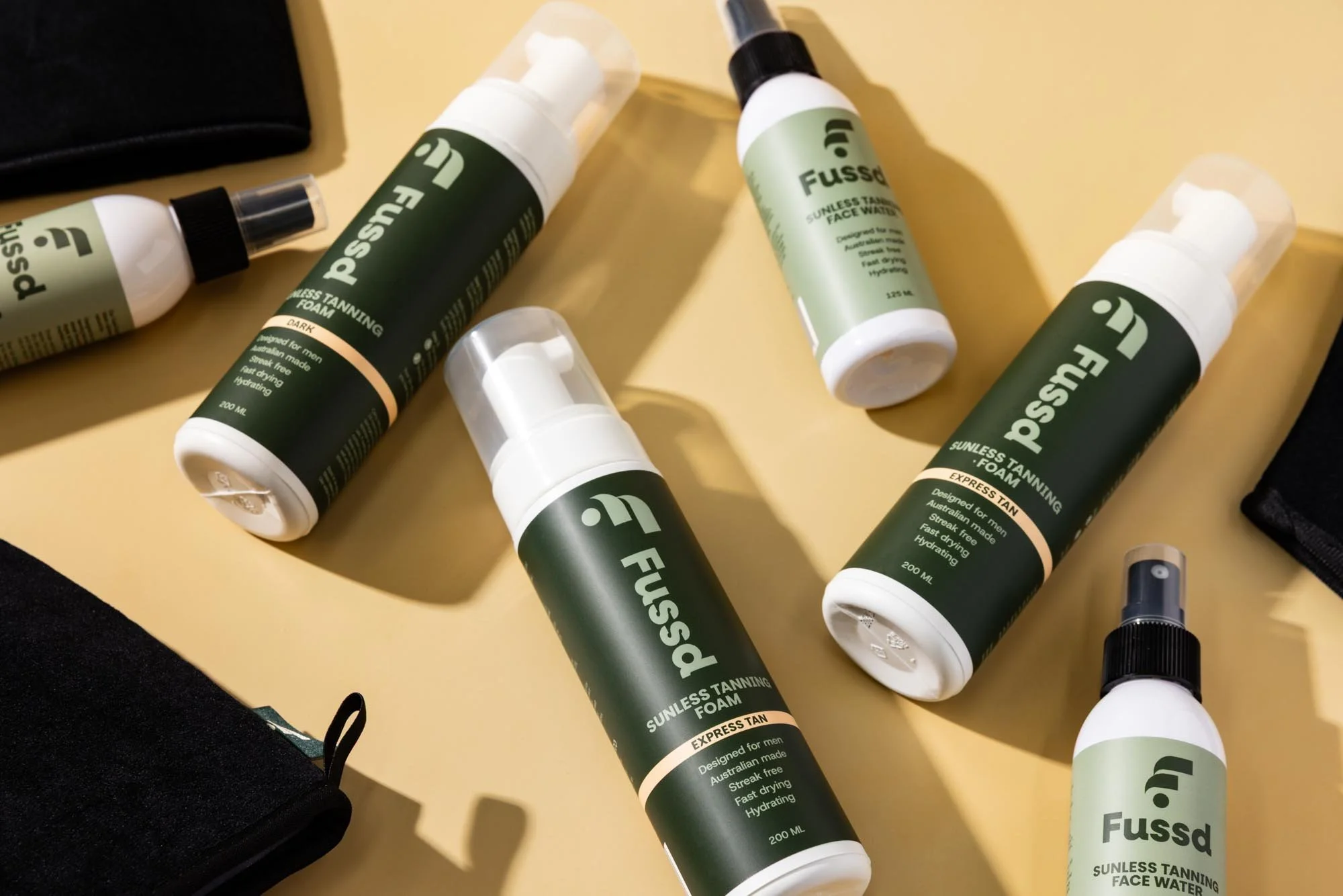 A collection of male tanning products on a yellow background