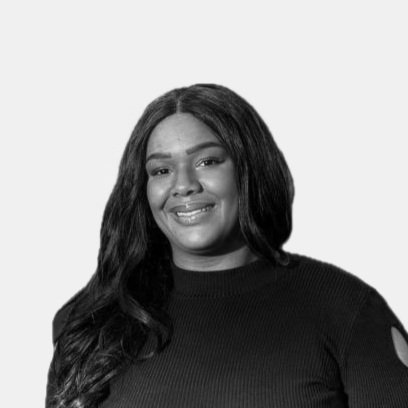 Schwarz-Weiß-Bild einer lächelnden Frau mit langen, dunklen Haaren in einem dunklen Oberteil, auf hellem Hintergrund.