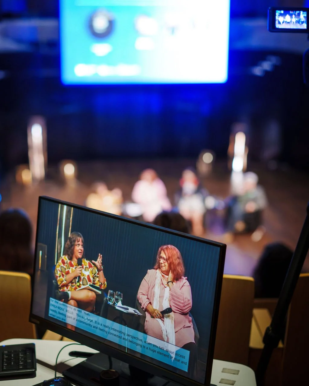 a close up of a screen with live captioning of two speakers from the tech desk.