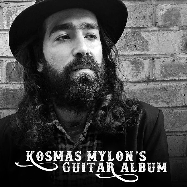 Black and white photo of a man with long hair and a beard, wearing a hat and a plaid shirt, looking to the side, standing in front of a brick wall. Text overlay reads 'Kosmas MyloN's Guitar Album'.