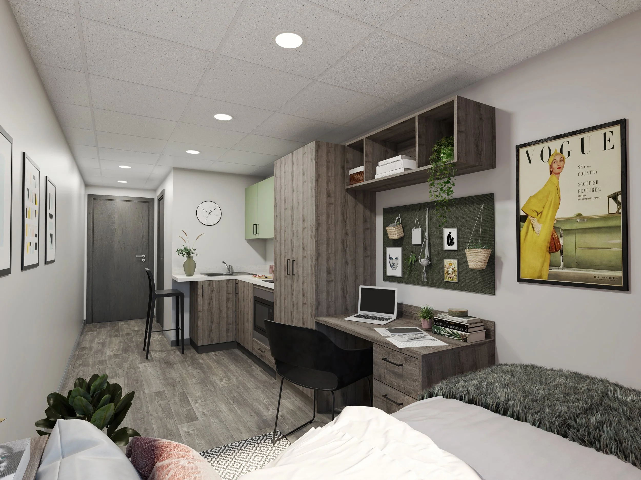 Modern studio apartment with a compact desk, laptop, shelves, artwork, kitchenette, and bed; minimalist decor and green accents.