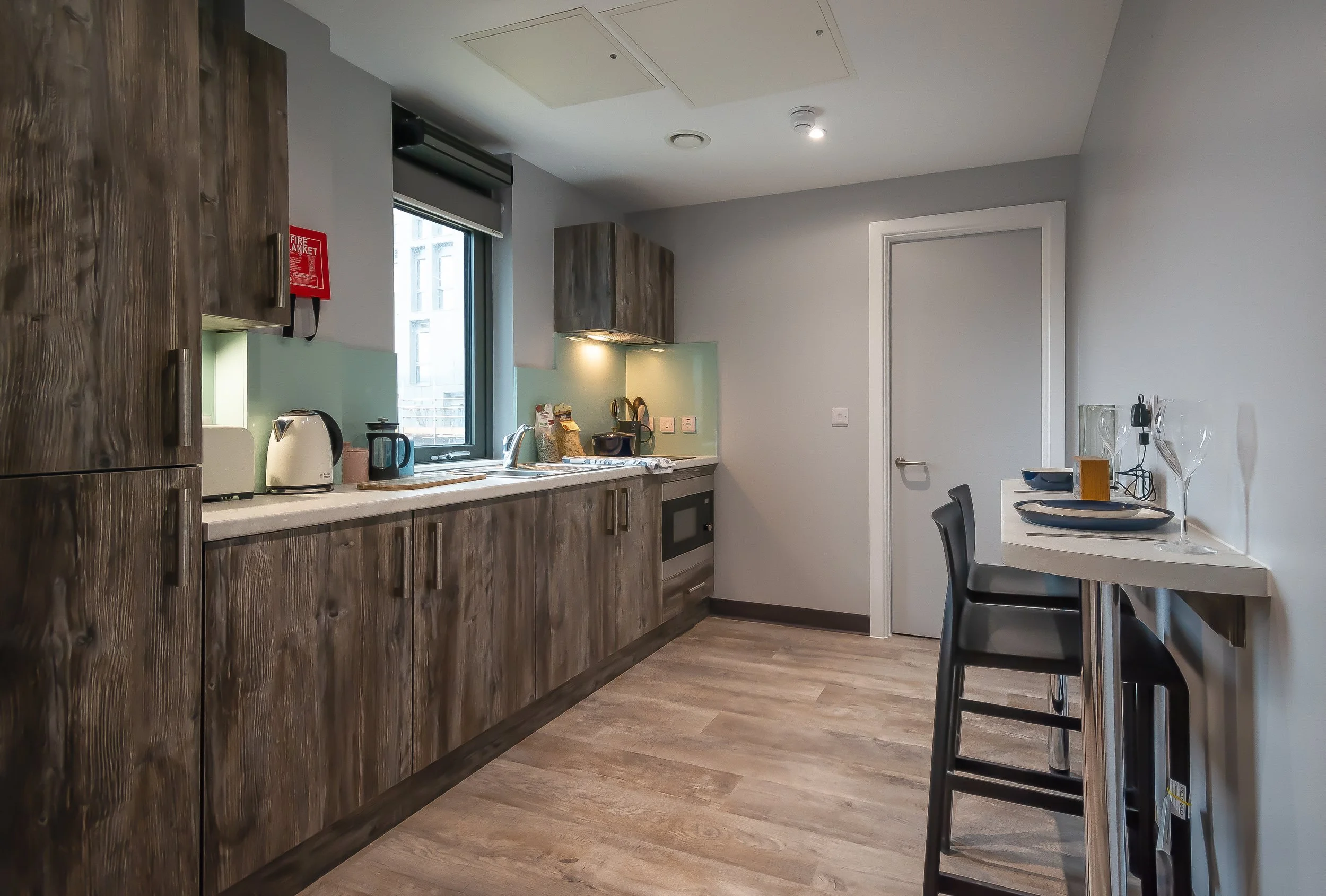 Modern kitchen with wood cabinets, countertop appliances, and a bar seating area.