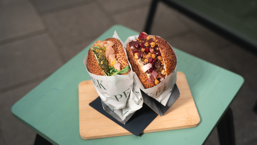Two PEK simit sandwiches on a wooden board