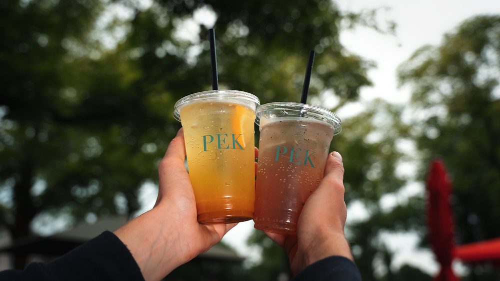 Two homemade PEK iced teas held up outside