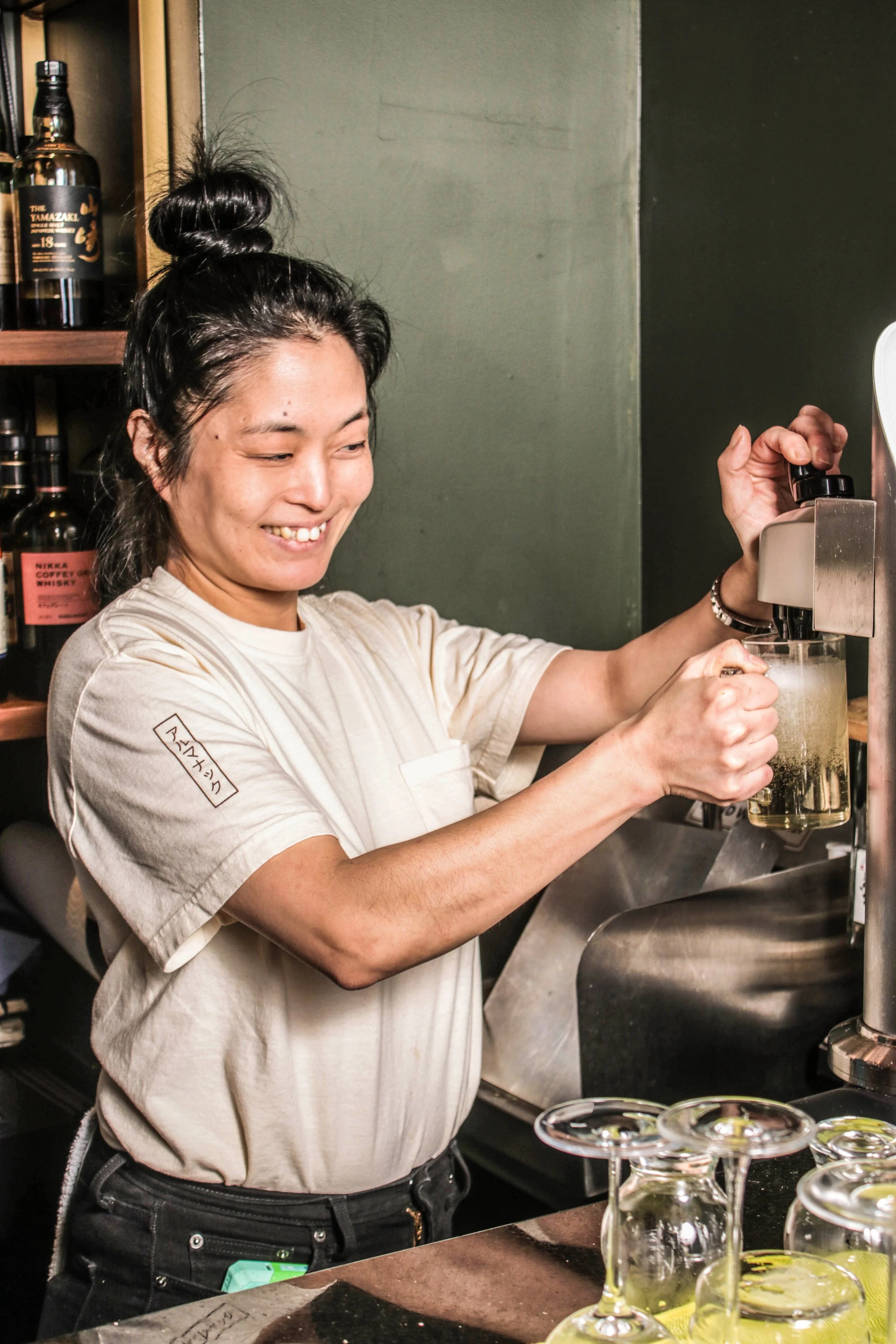 woman pouring highball in almanac cream tee shirt
