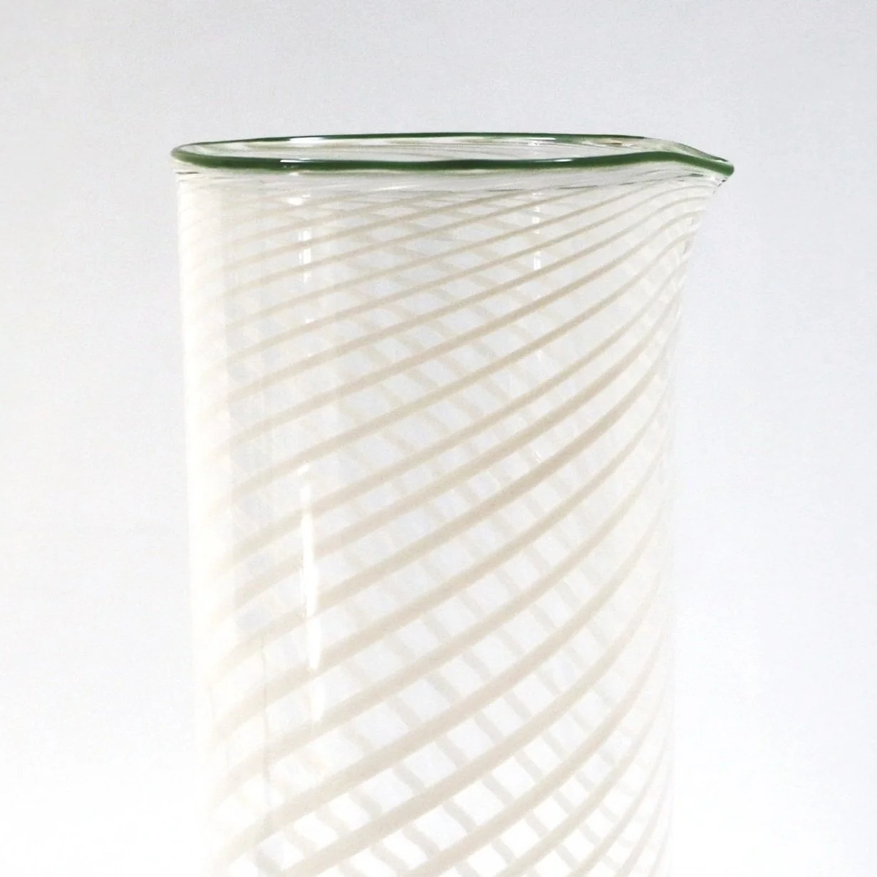 Caraffa di vetro con motivo a spirale bianco trasparente, visibile su sfondo bianco.