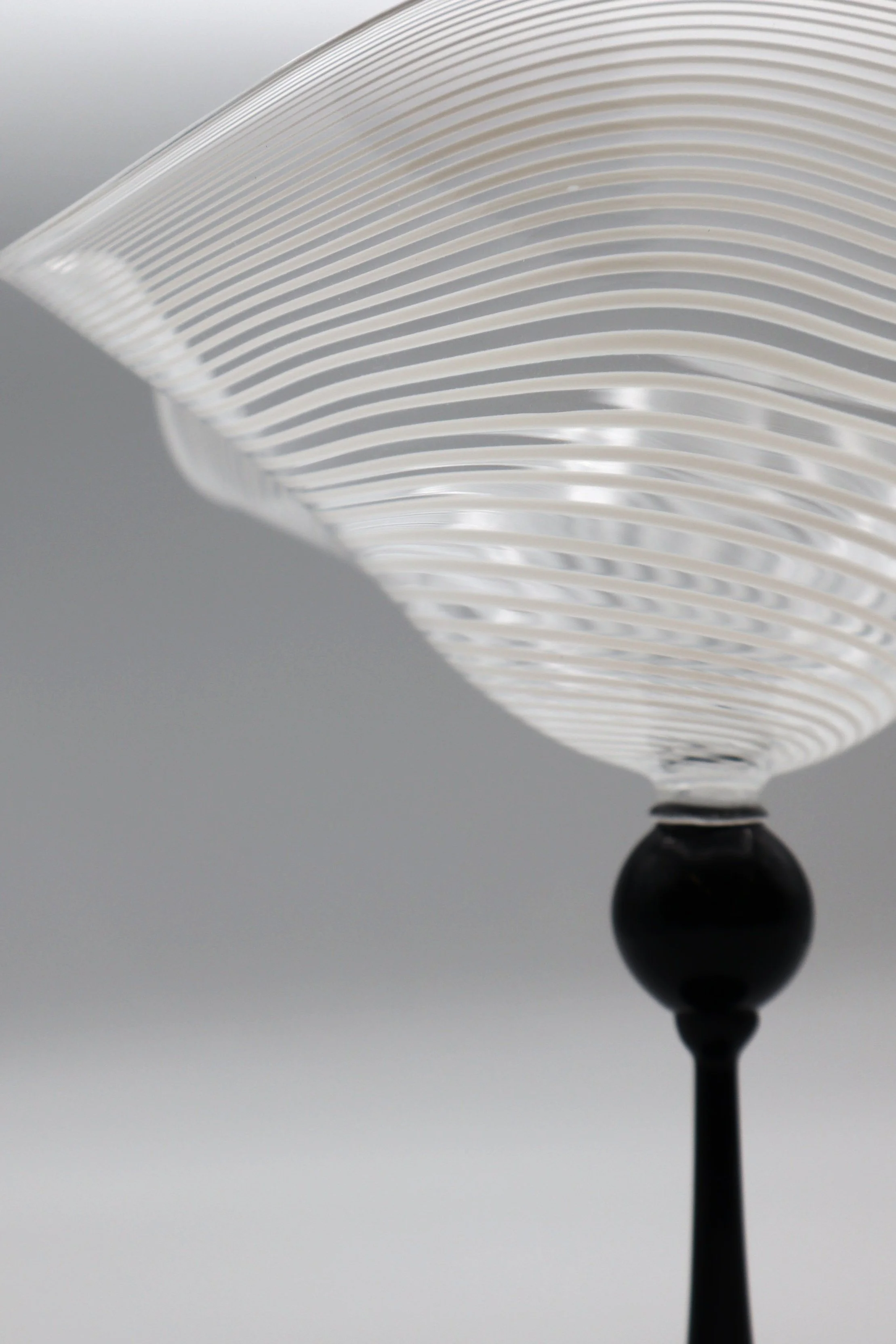 Lampi decorativi moderni con paralumi in vetro trasparente con righe orizzontali e base nera.