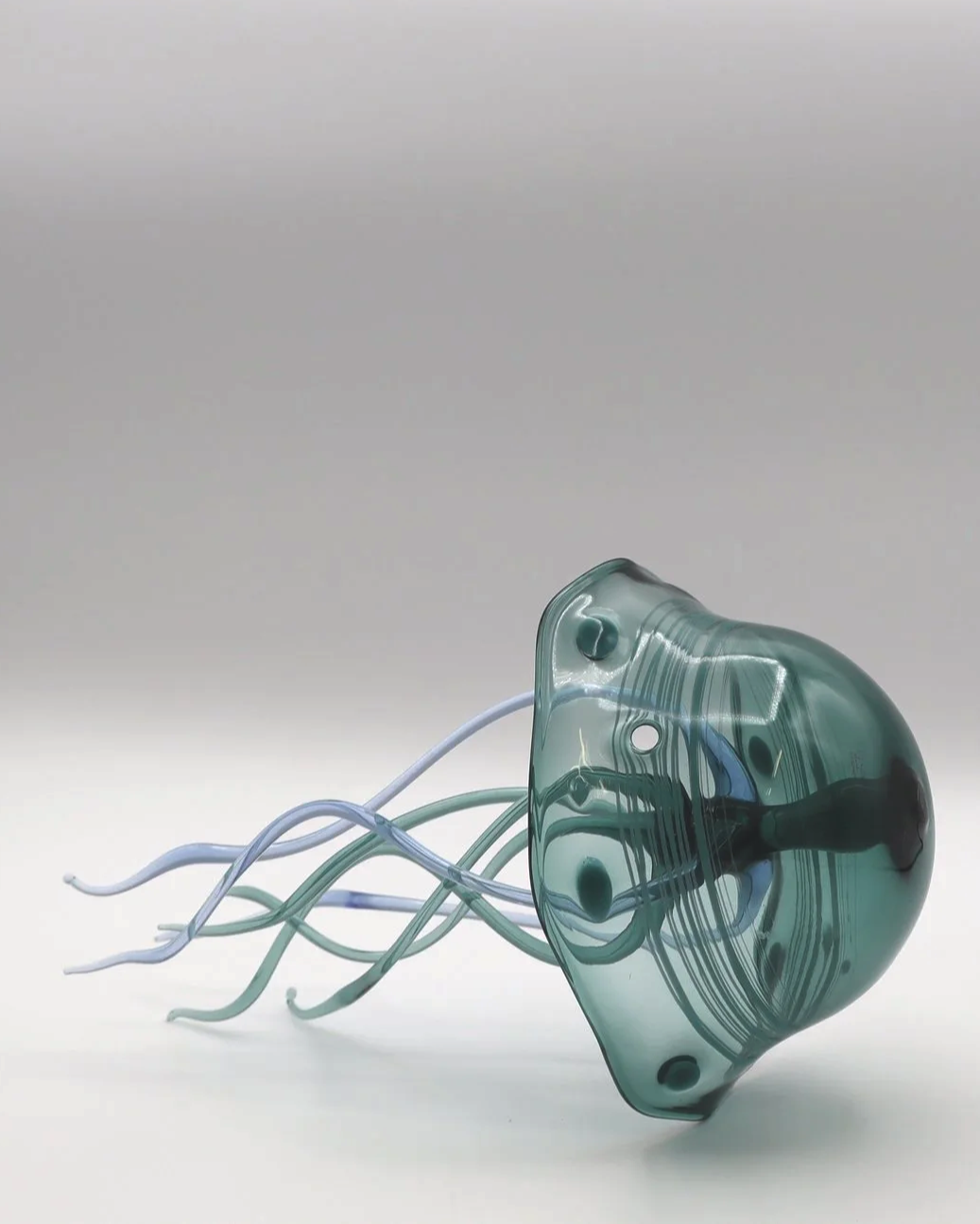 Scultura in vetro che assomiglia a una medusa con tentacoli sottili e curvi