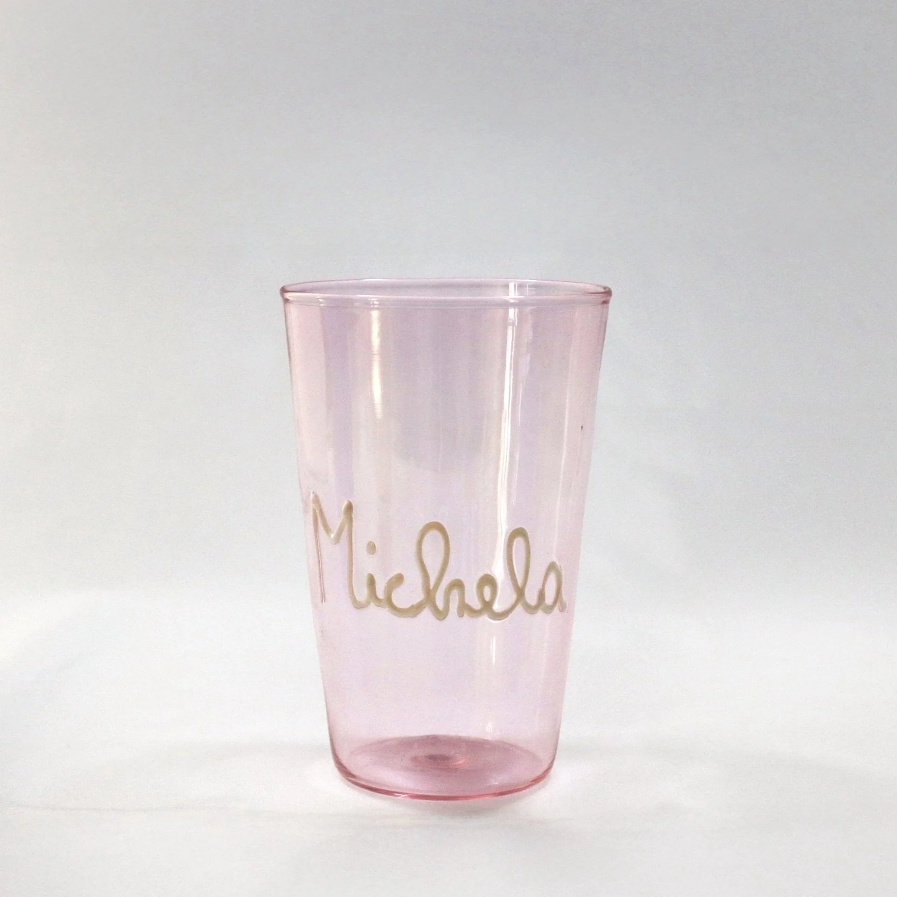 Bicchiere di vetro rosa con la scritta 'Michela' in rilievo.