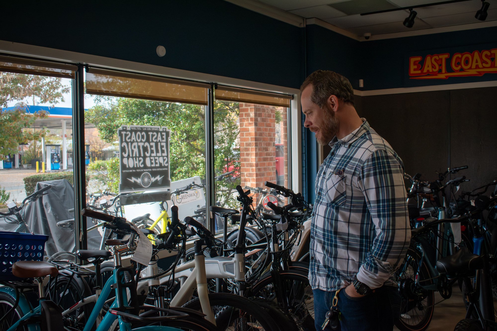 Carini stands in his second small business in Carrboro, East Coast Electric Speed Shop, which he founded in 2019. Despite Linda's financial struggles, Carini opened a second location of East Coast Electric in Raleigh in 2023.