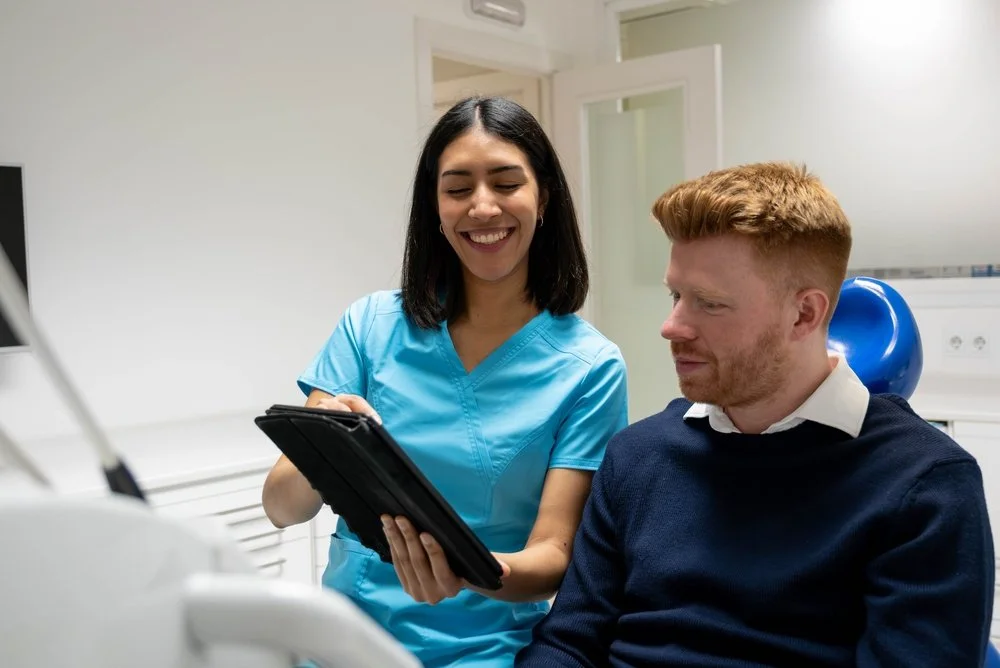 dentist explaining restorative dentistry treatment to patient using dental model to restore long term oral health