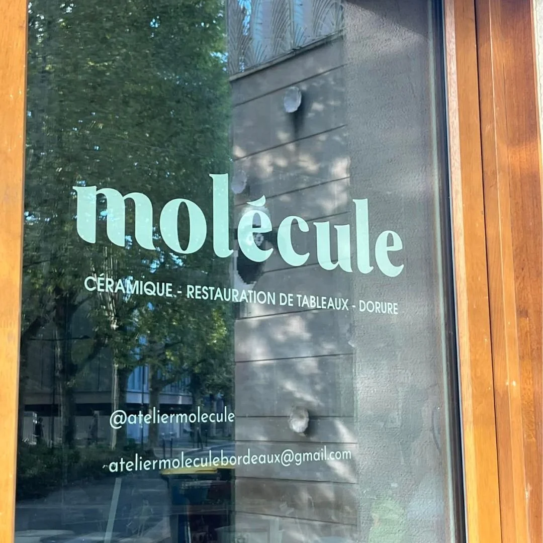 Vitrine en verre d'une boutique en bois avec le nom 'molecule'.