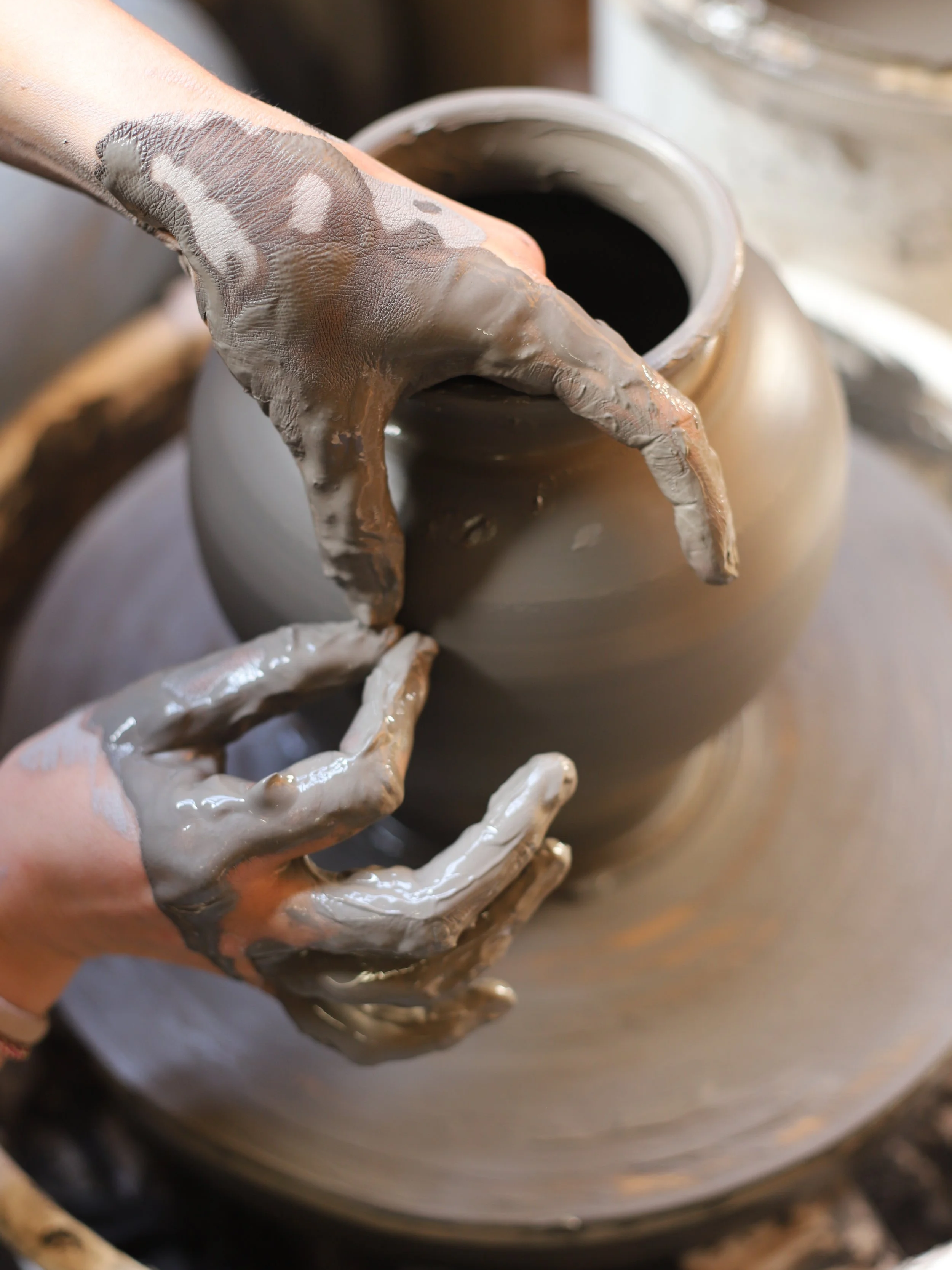 Geste de mains qui tournent un grand pot en argile