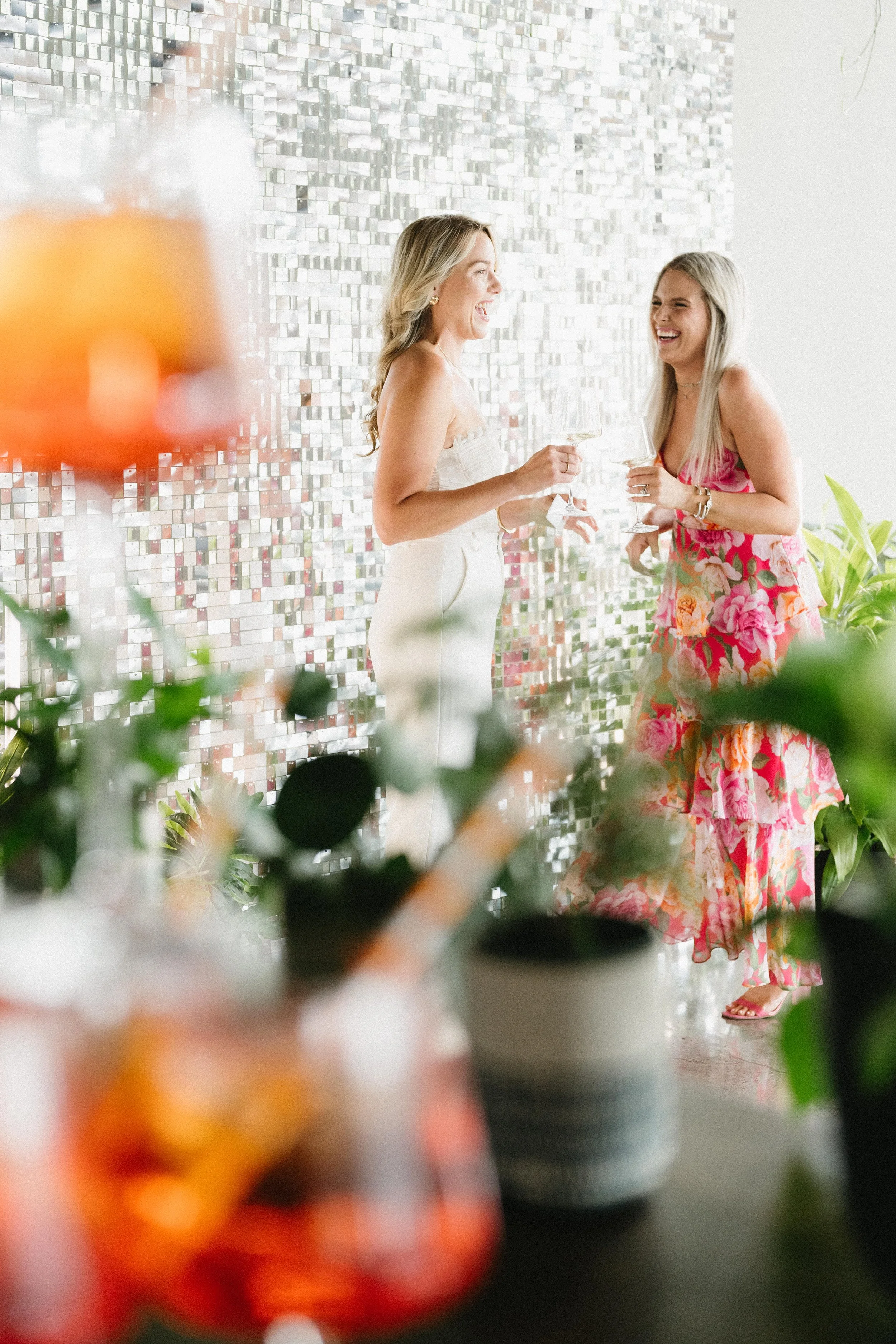Kansas City wedding guests enjoying digital photo booth with shimmer wall and tropical greenery