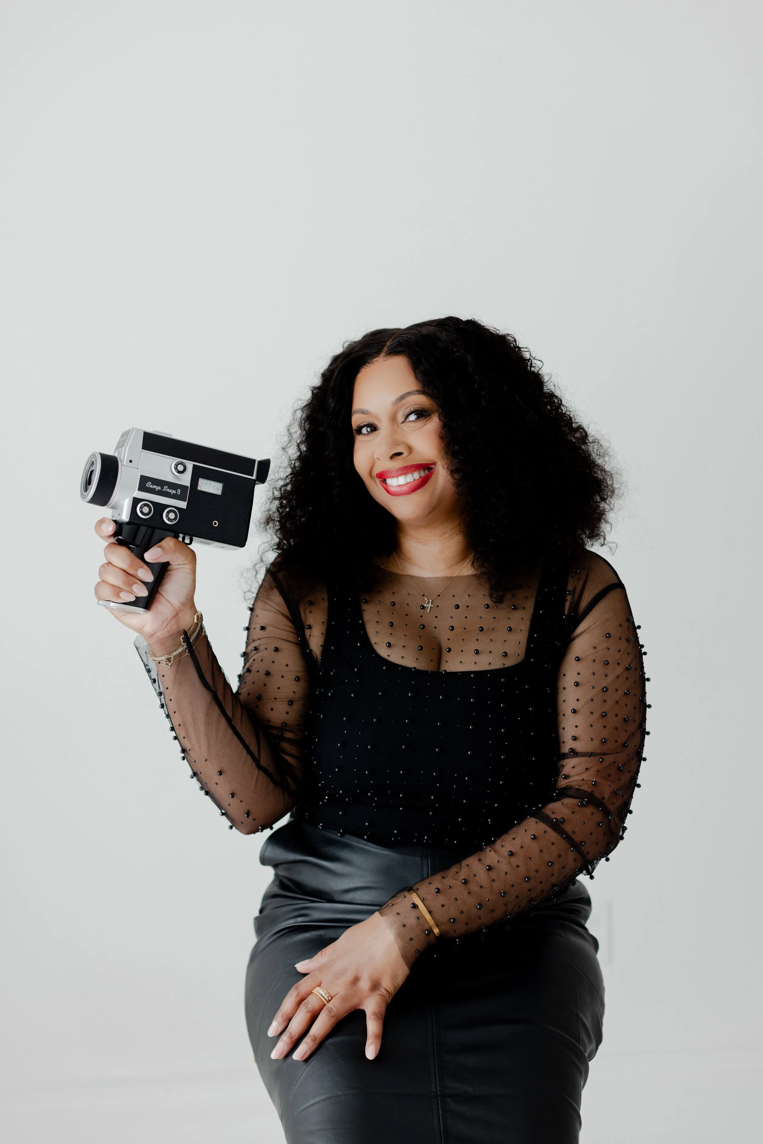Christa Ellis, founder and owner of Lumen Events Kansas City, holding a vintage camera