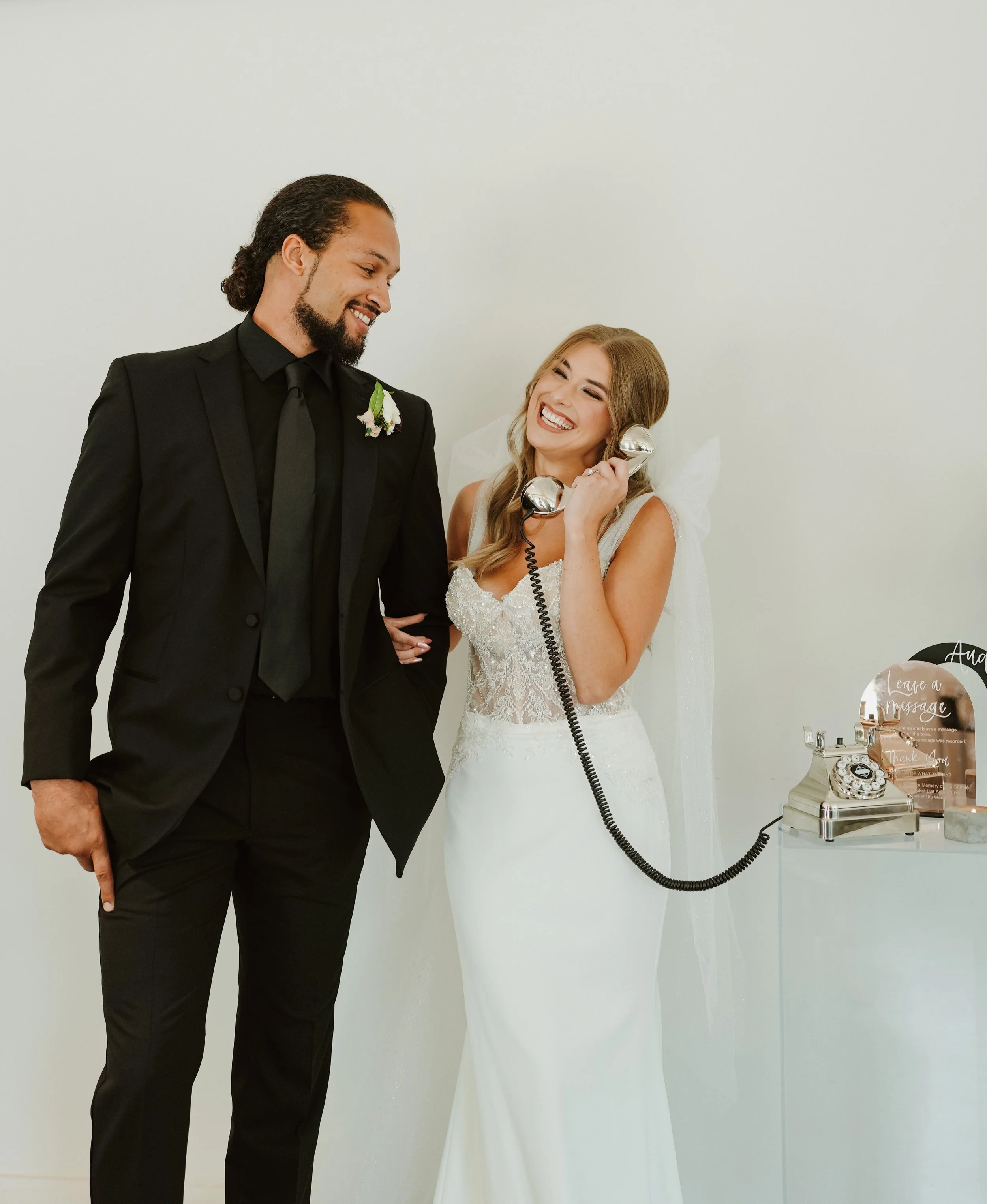 Bride and groom using chrome vintage rotary phone audio guest book together at Kansas City wedding reception